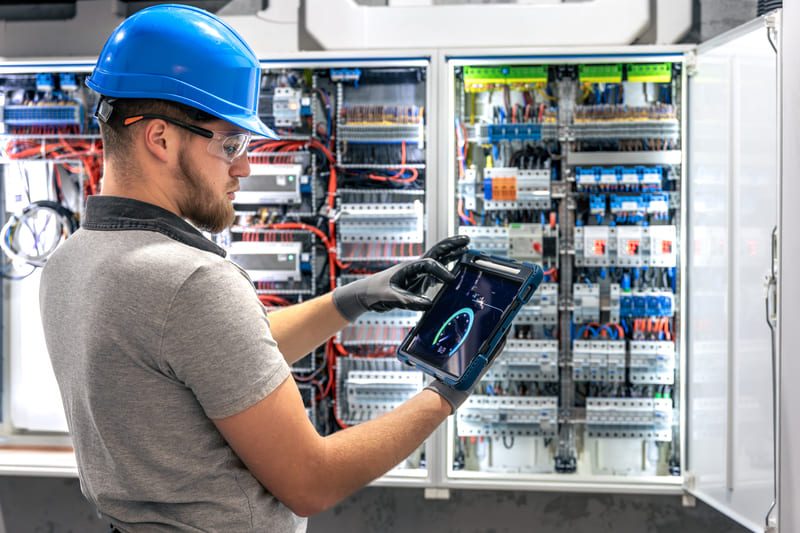 electrician with tablet working switchboard digital tools use e1775469250537