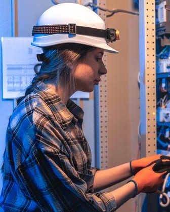 woman electrician repairs electrical panel technical room panel maintenance e1775470661615